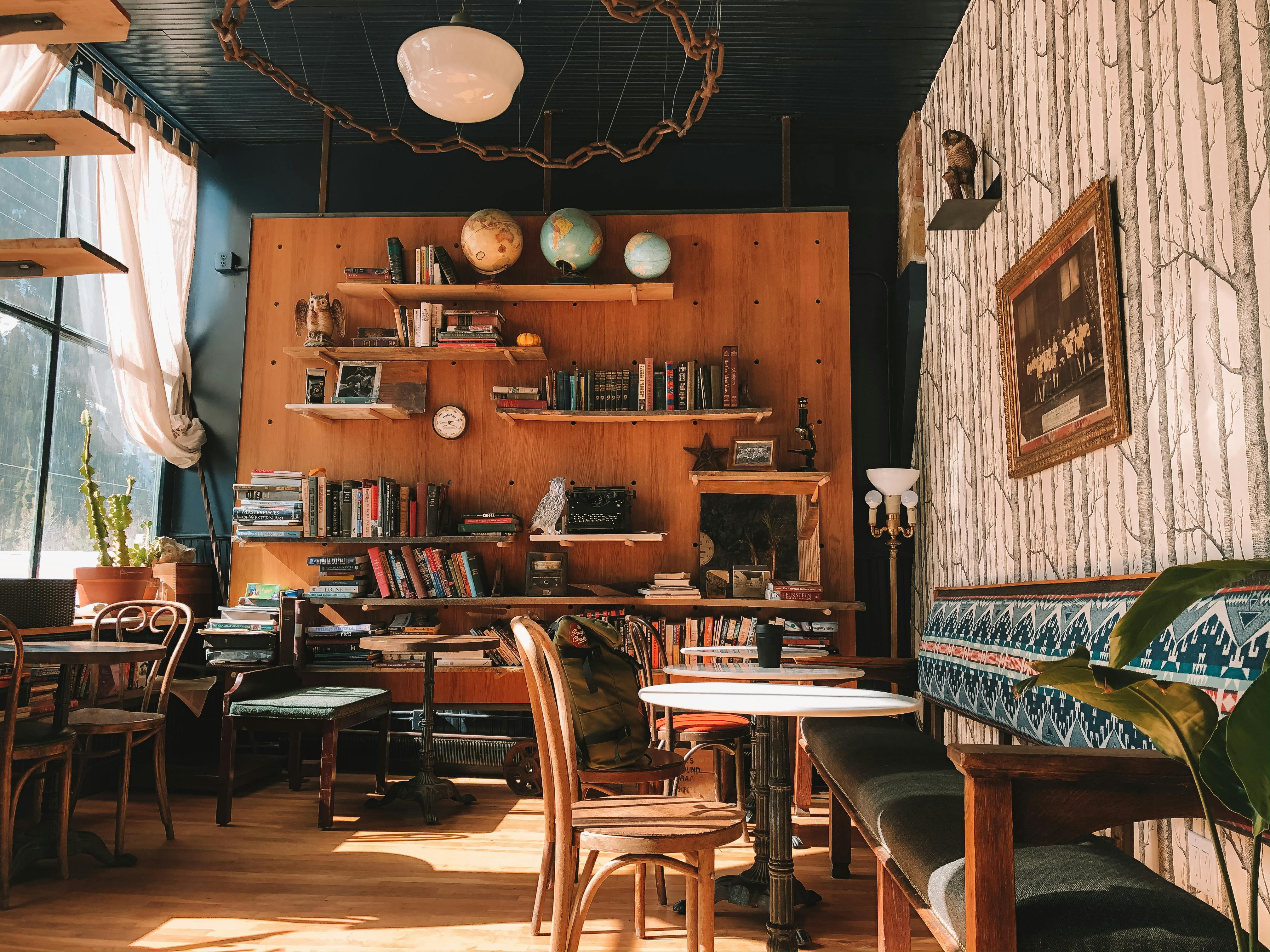 Cozy cafe interior with wooden shelves, books, and decor.